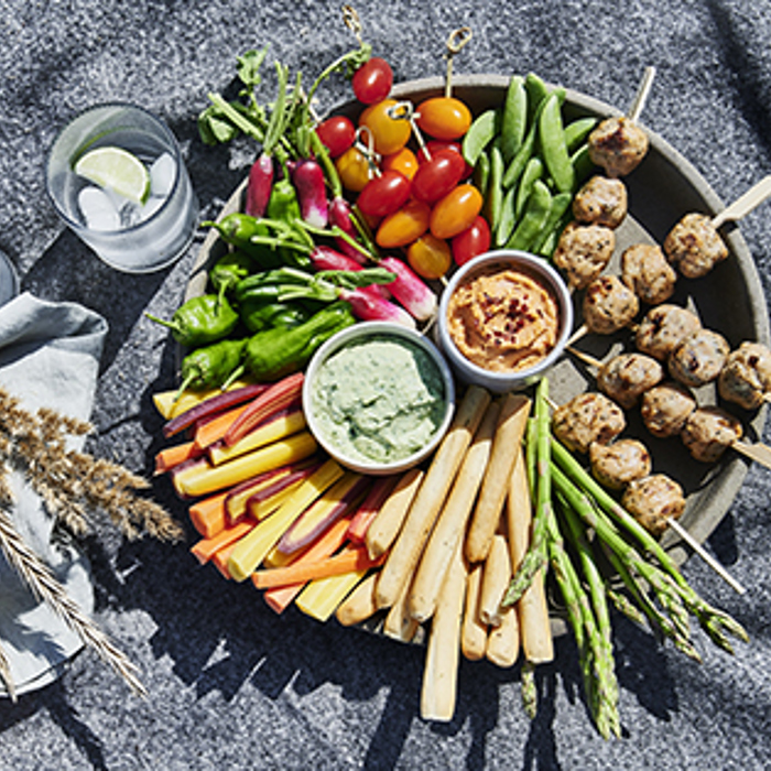 Snackfad med kyllingekødboller på pind, grøntsager og to slags humus